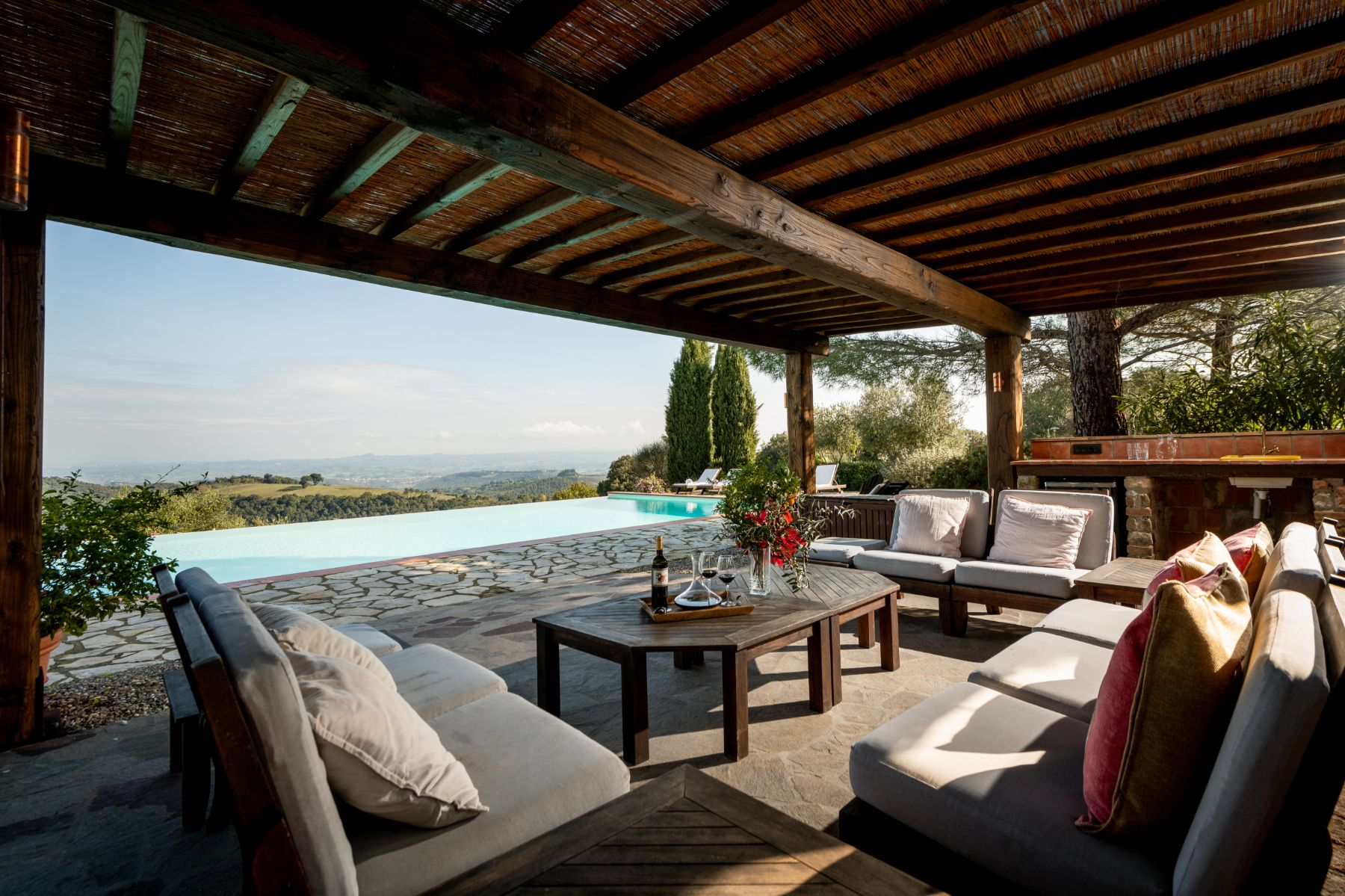 Outdoor pool lounge area with sofas at Villa San Barberino in Tuscany