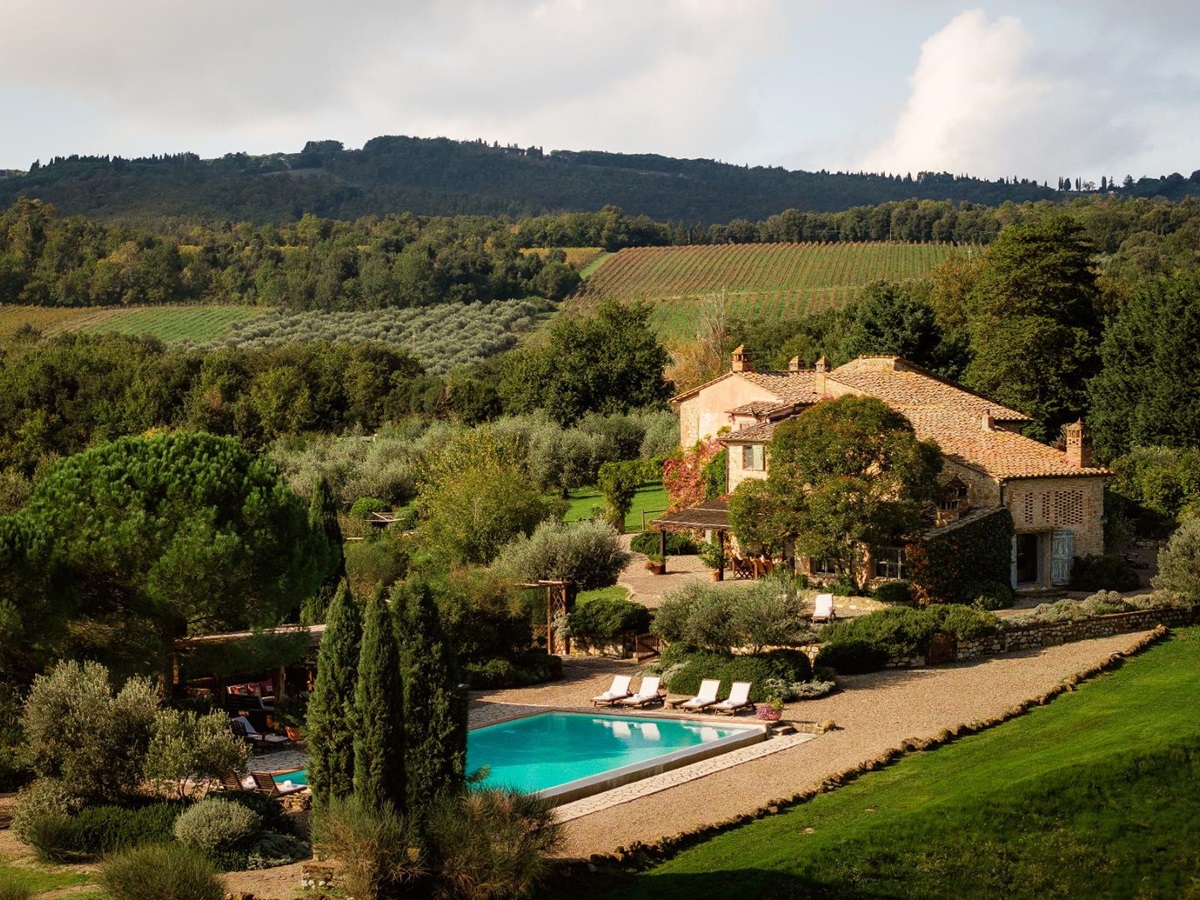 Drone view of Villa San Barberino with view of the pool area surrounded by trees in Tuscany