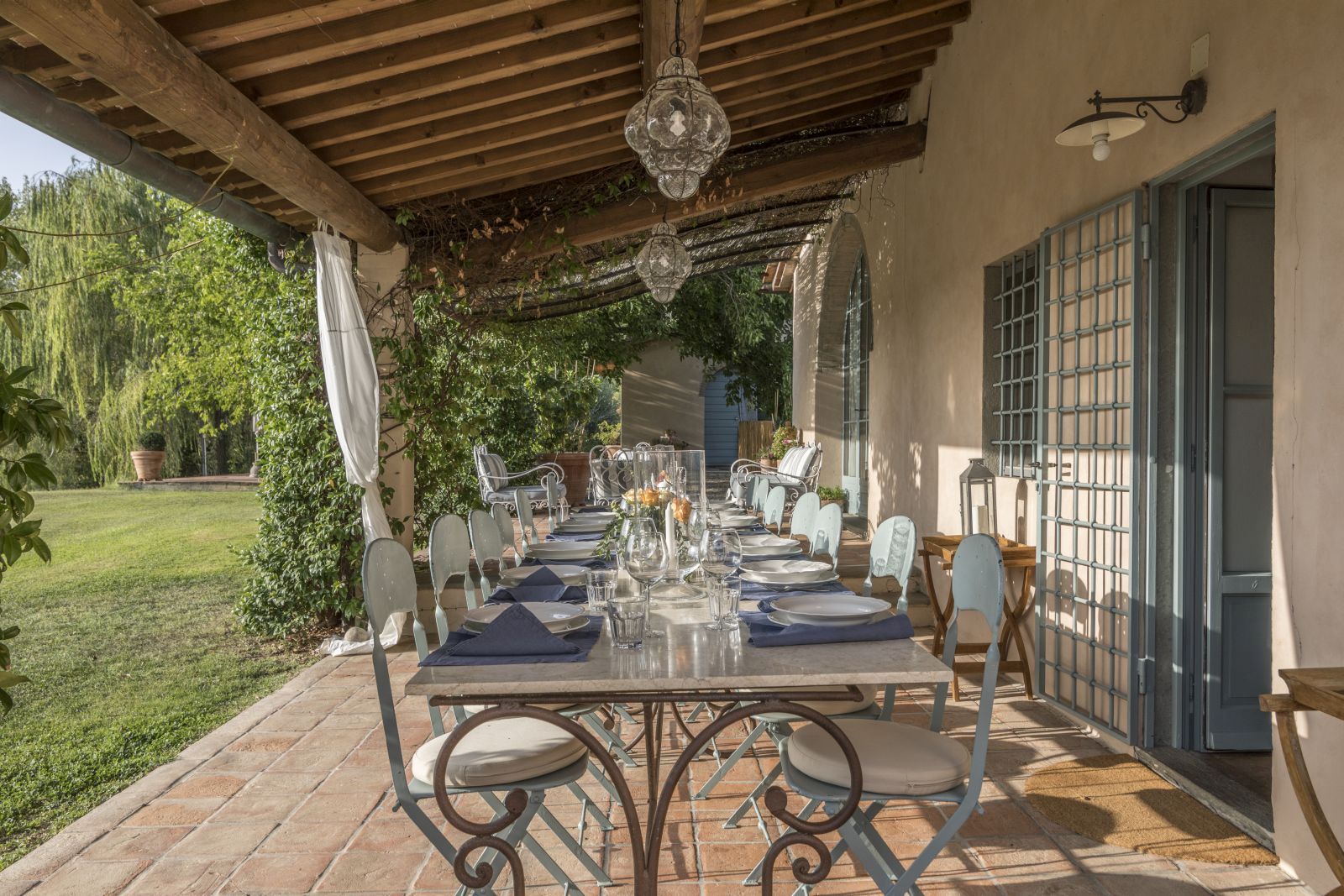 Outdoor dining terrace with table and chairs at Villa San Casciano in  Tuscany
