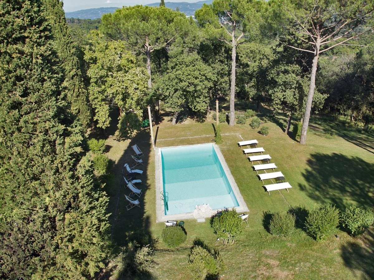 Ariel view of the outdoor pool surrounded by trees at Villa San Morello in Tuscany