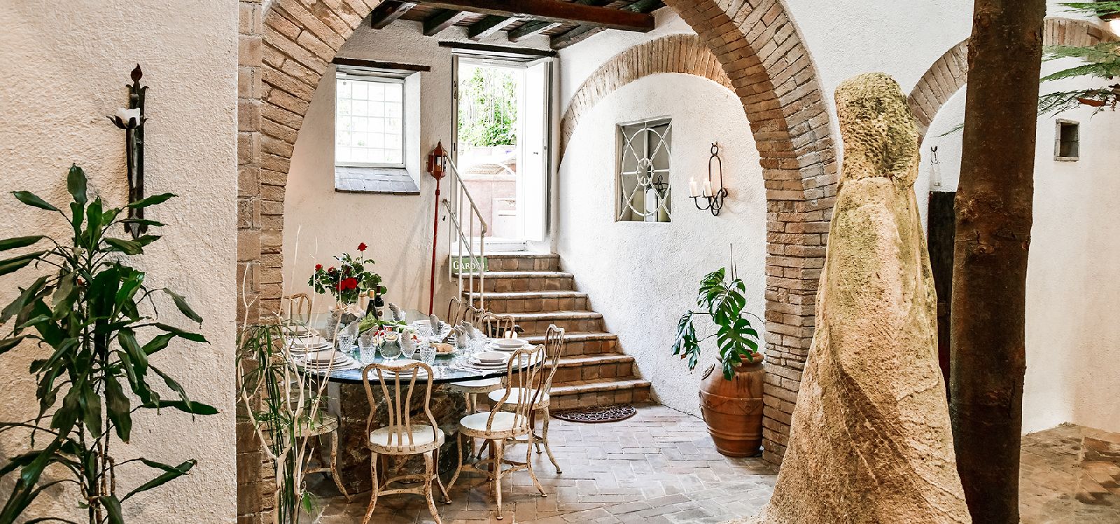 Stone archway in hallway with stairs at Casa Mahler in Umbria