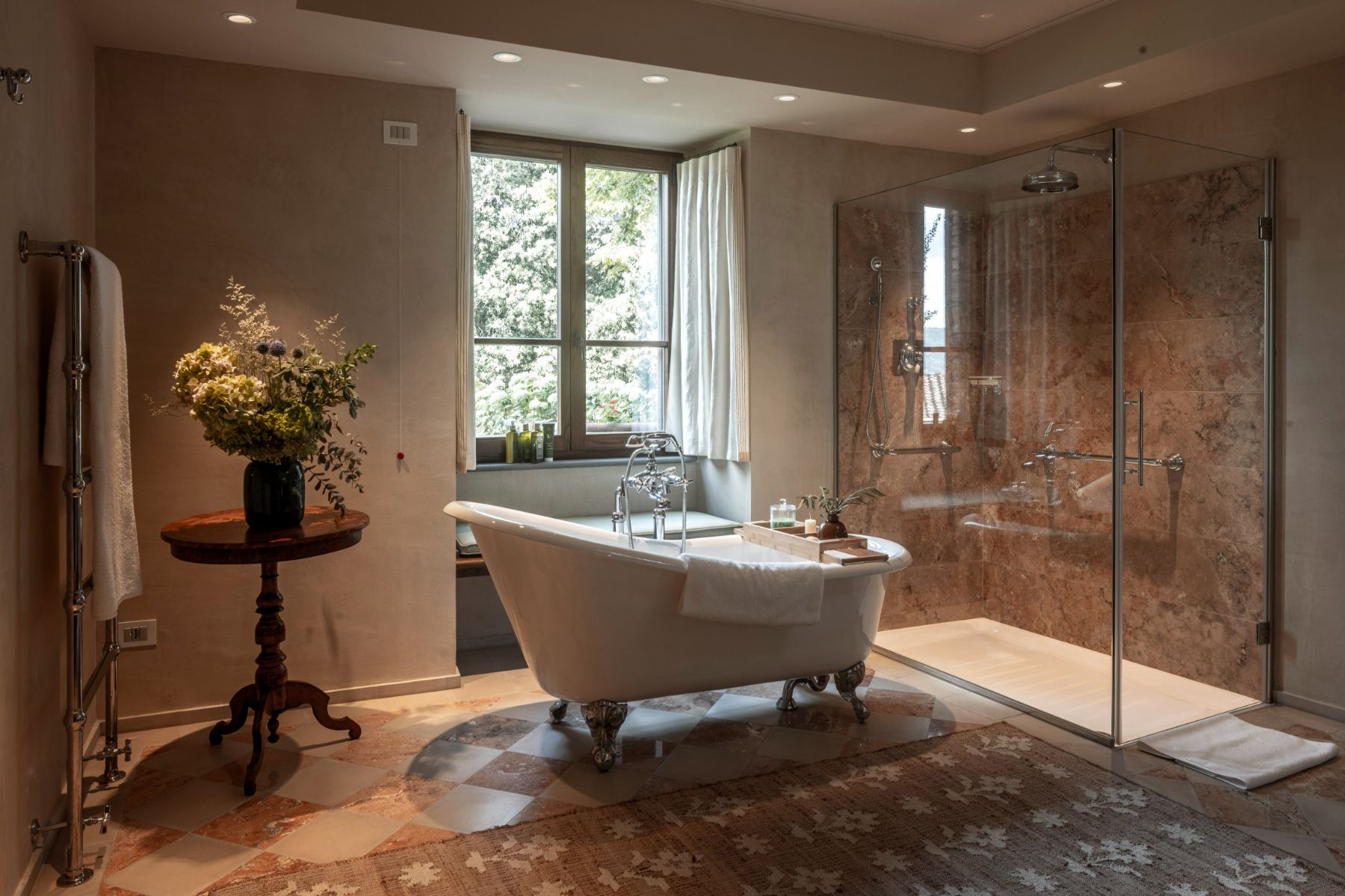 Bathroom with large glass shower and white bath tub in front of a window at Villa Il Convento in Umbria
