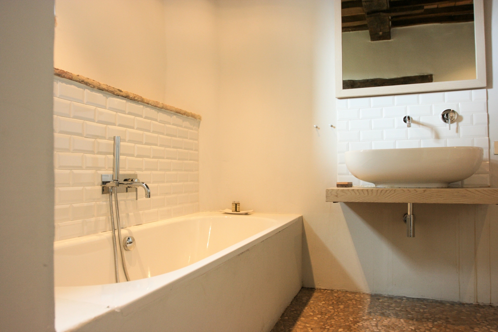 White bathroom with bath, sink and large mirror at La Spiga in Umbria, Italy