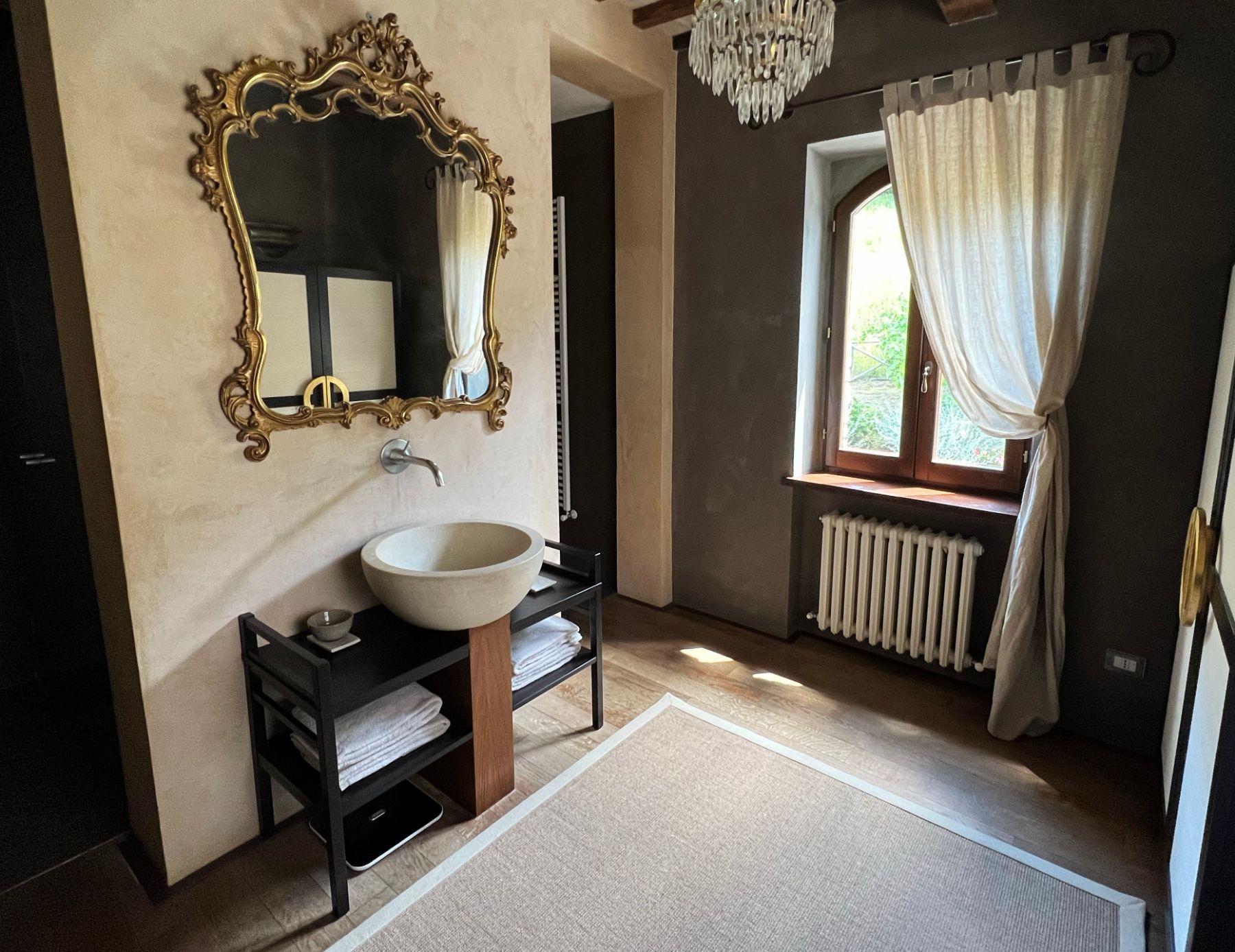Bathroom with gold mirror at L'Eremo in Umbria