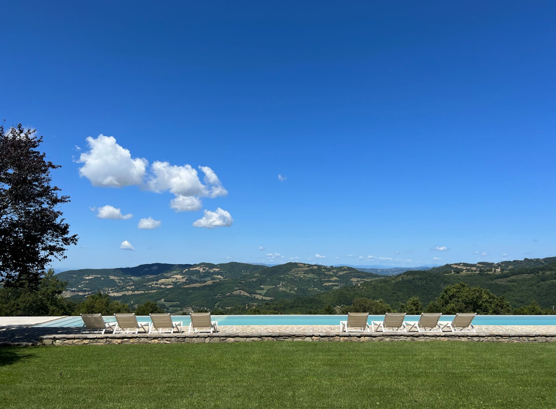 Pool loungers and view at L'Eremo in Umbria