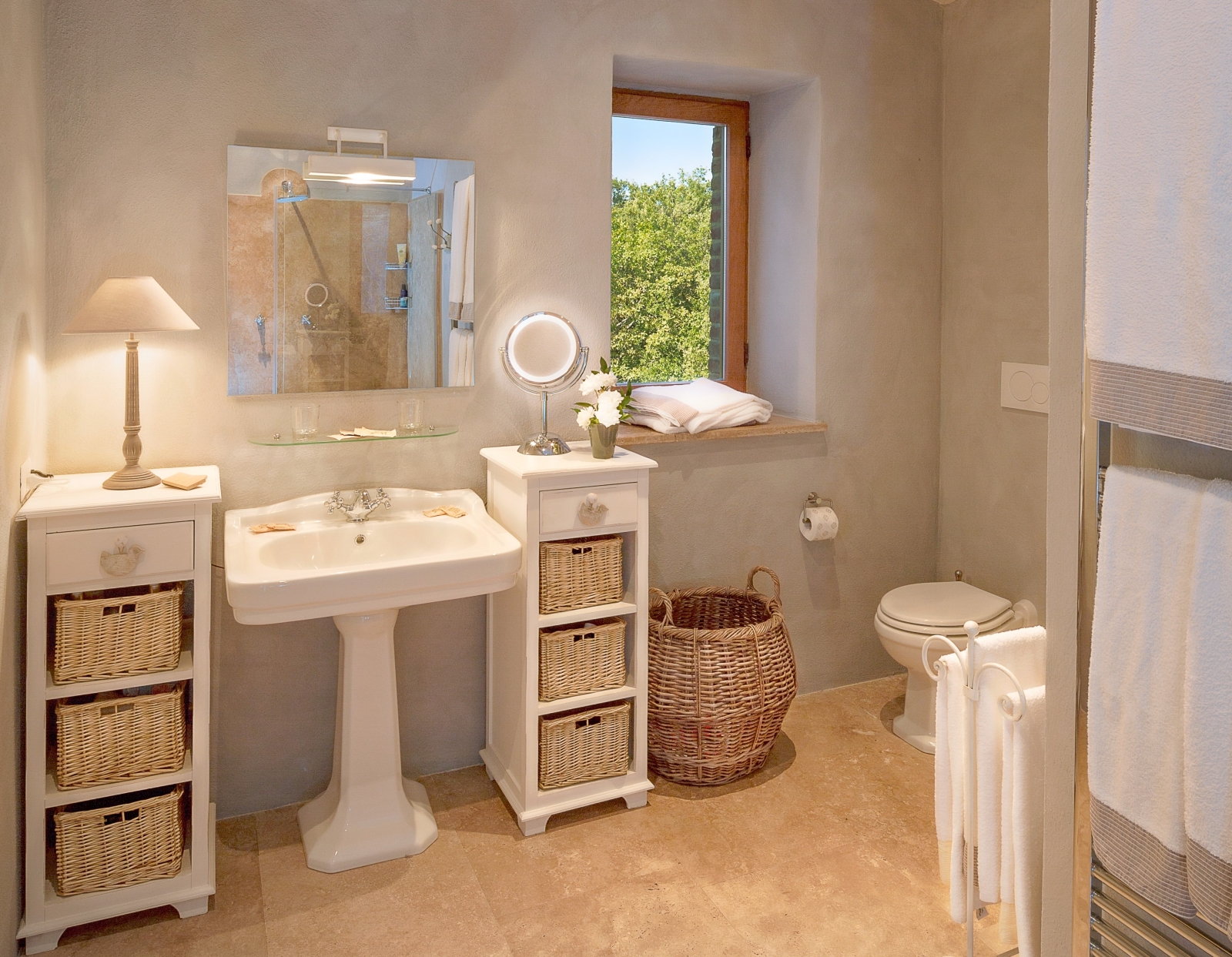 Bathroom with sink, mirrors, shelves, lamp, toilet and towel rail at Monticello in Umbria, Italy