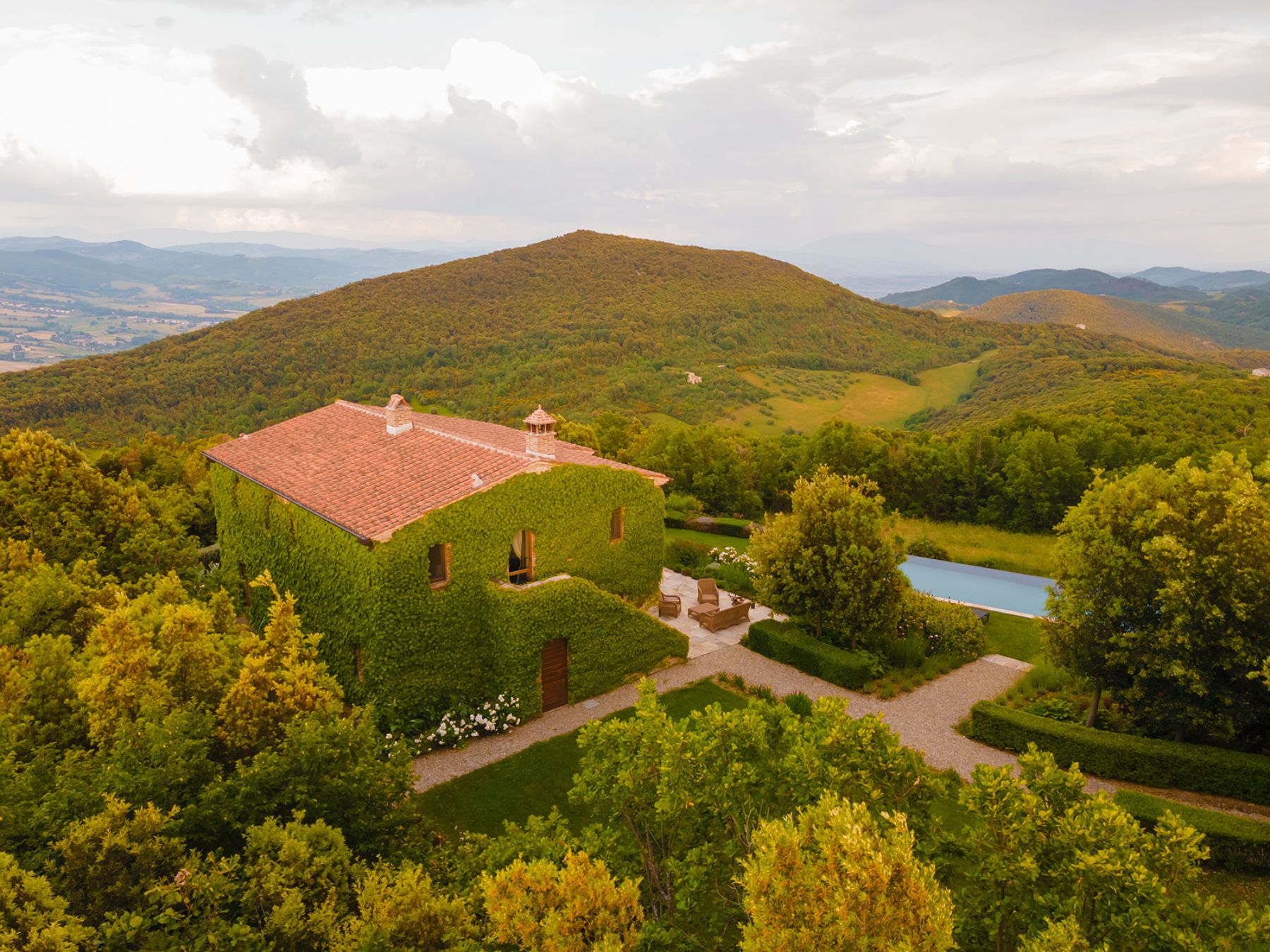 Outdoor drone view of Villa Monticello at the back of the property with view of the pool and rolling hills