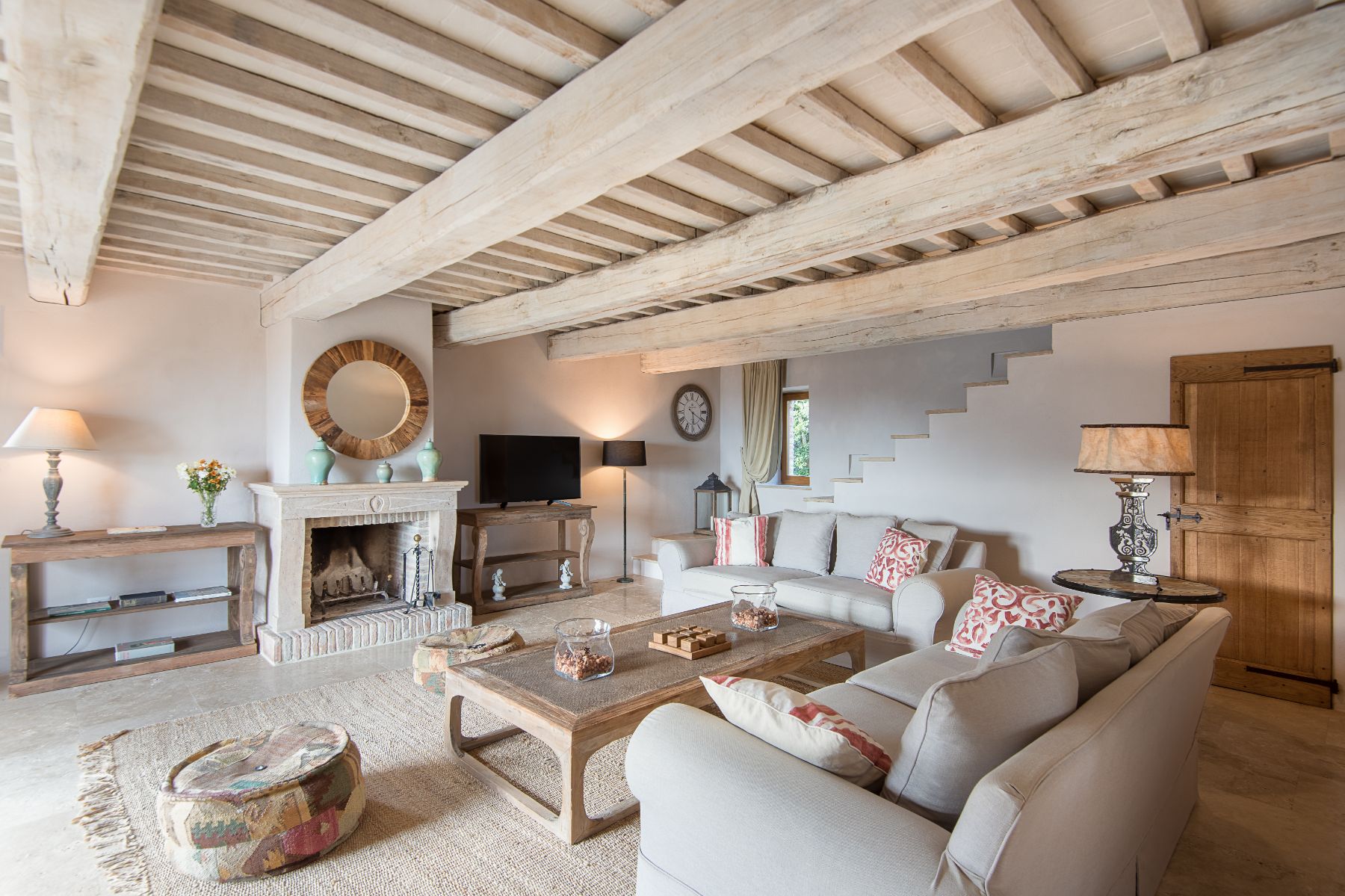 Living room with wooden beams and cream coloured sofas with a tv at Villa Monticello in Umbria