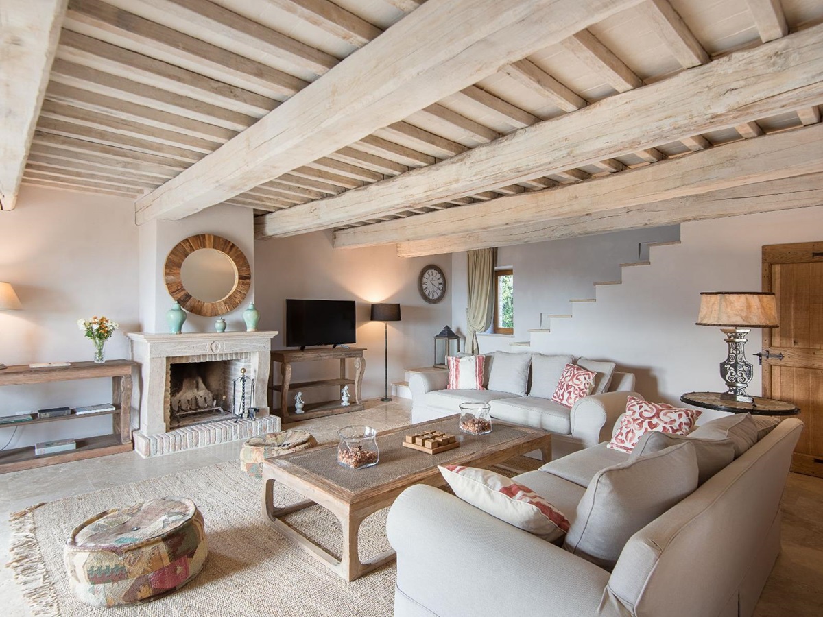 Living room with wooden beams and cream coloured sofas with a tv at Villa Monticello in Umbria