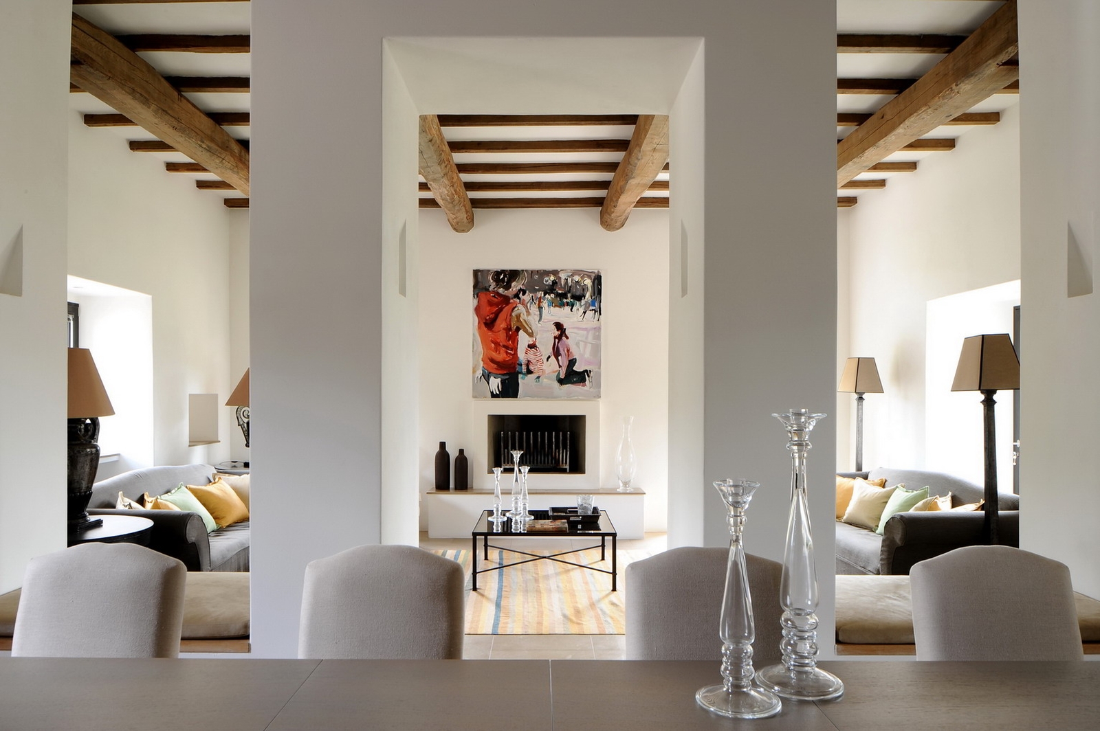 Dining table with grey chairs and living room behind at Villa Arrighi in Umbria