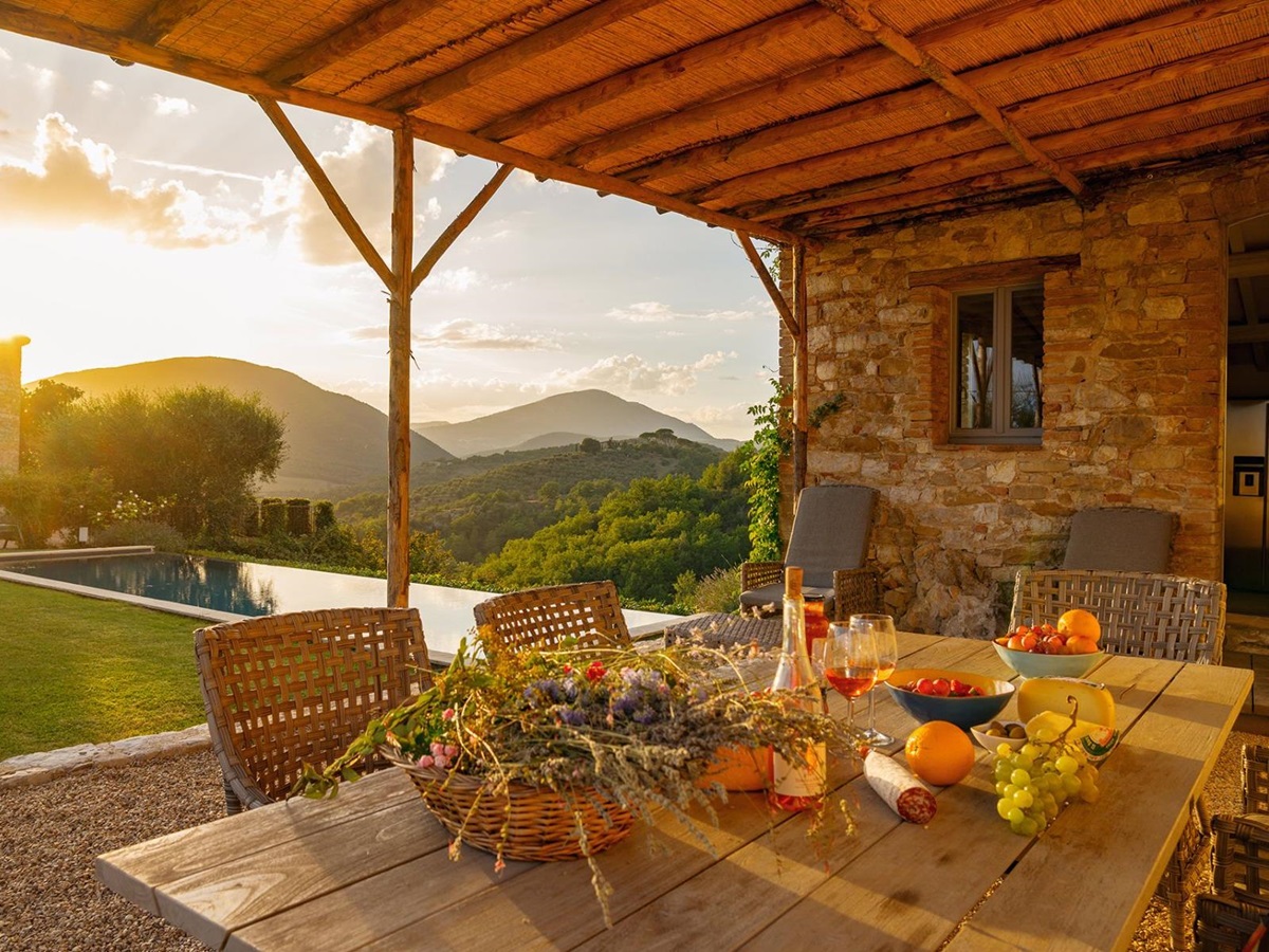 Outdoor table with fruit and wine in the outdoor patio at Ville del Conte in Umbria with view of the outdoor pool