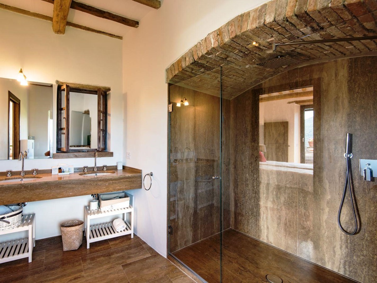 Bathroom with big walk in shower in brick alcove and two sinks at at villa del conte in umbria, Italy