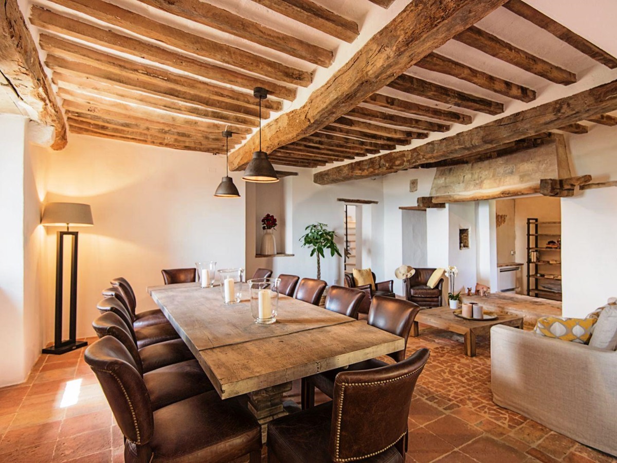Dining area with beamed ceiling, long wooden table and 12 chairs at villa del conte in umbria, Italy