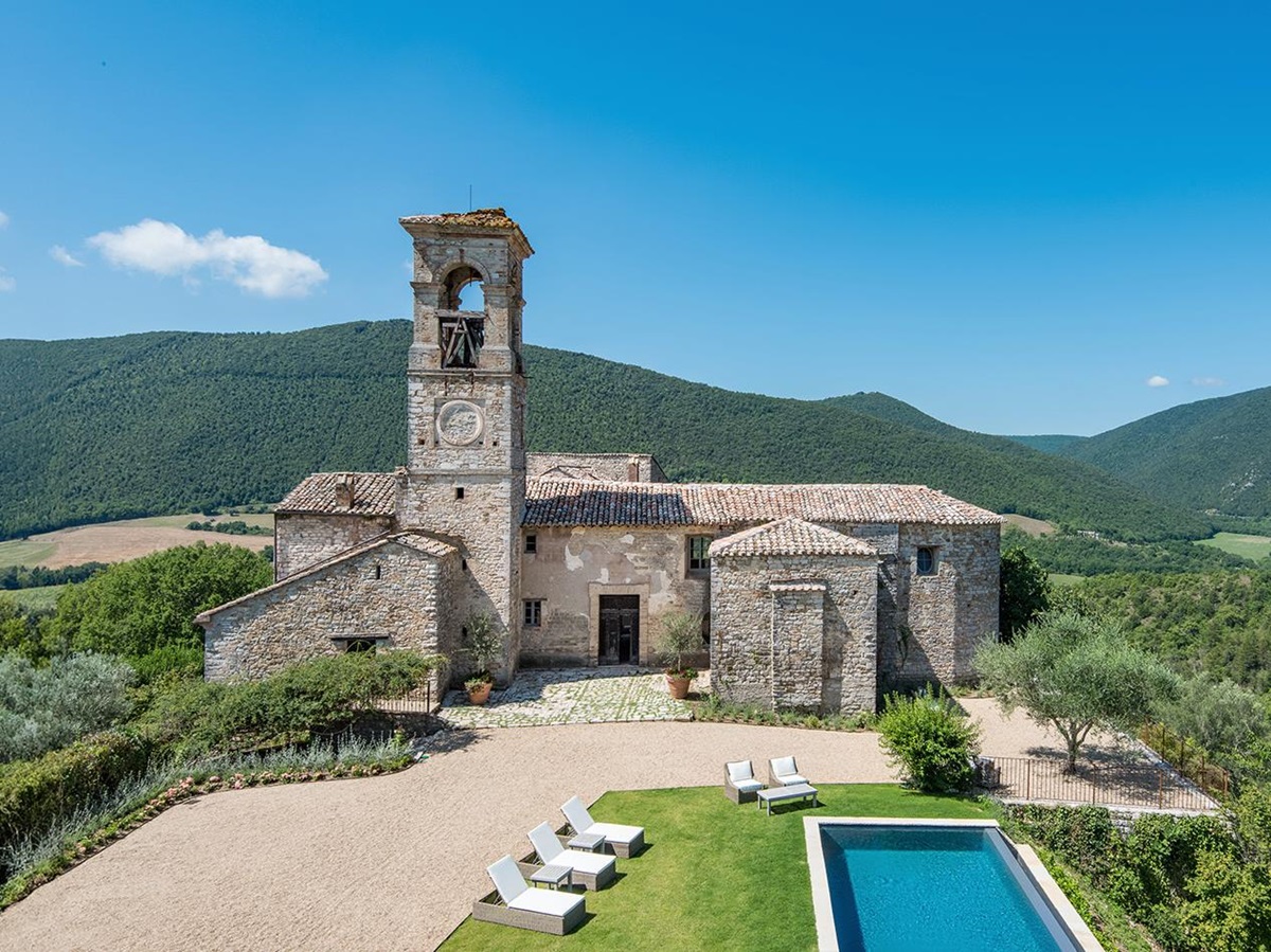 Exterior view of the pool and main building at Villa del Conte in Umbria