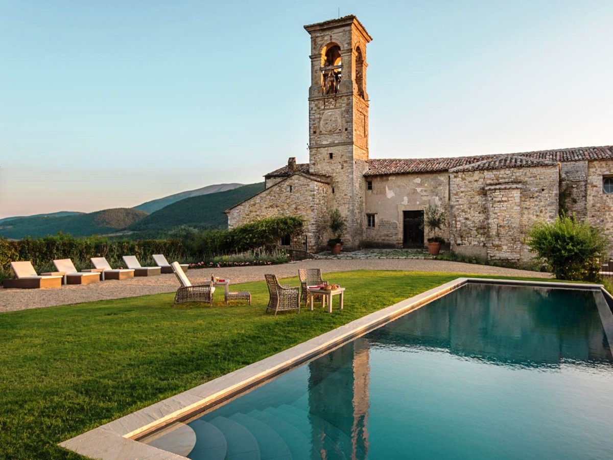 view over pool with castle building in the background at villa del conte in umbria, Italy with view of hills