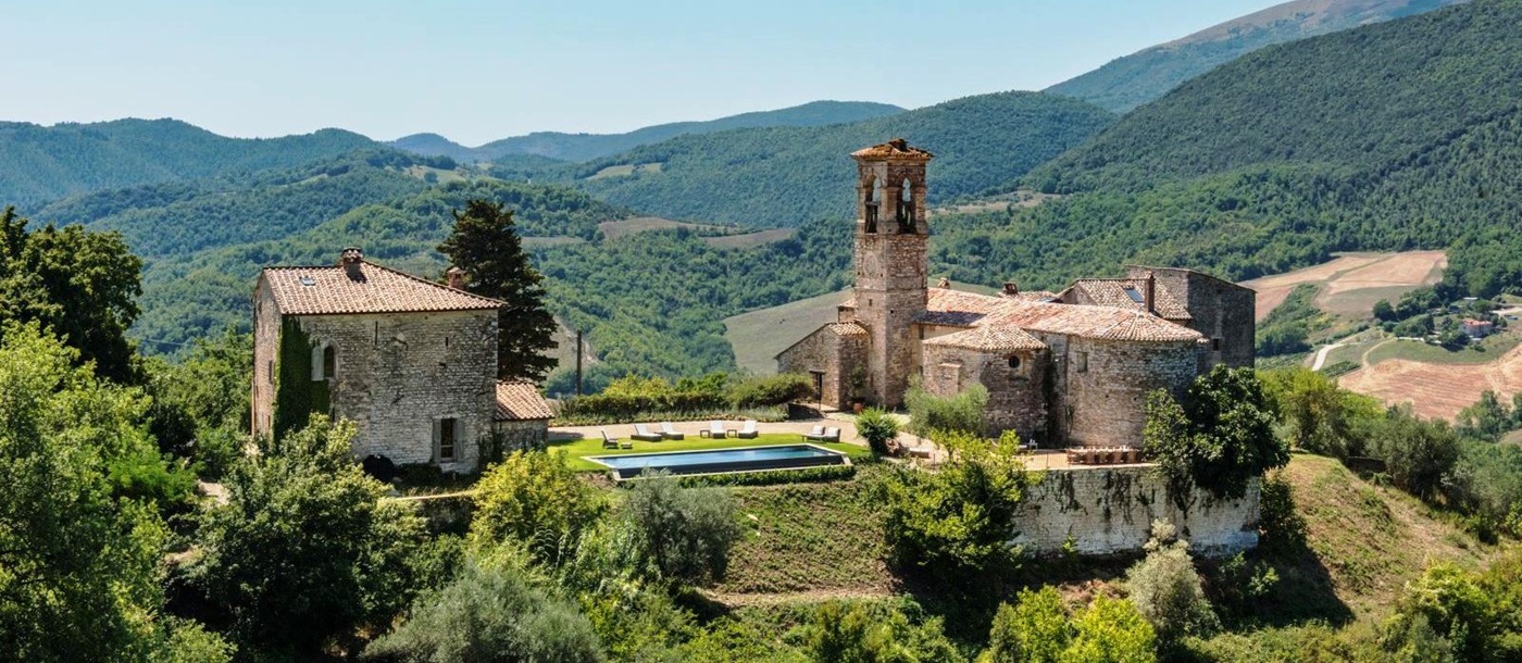 panoramic view of villa del conte in umbria, Italy with green wooded hills in the background