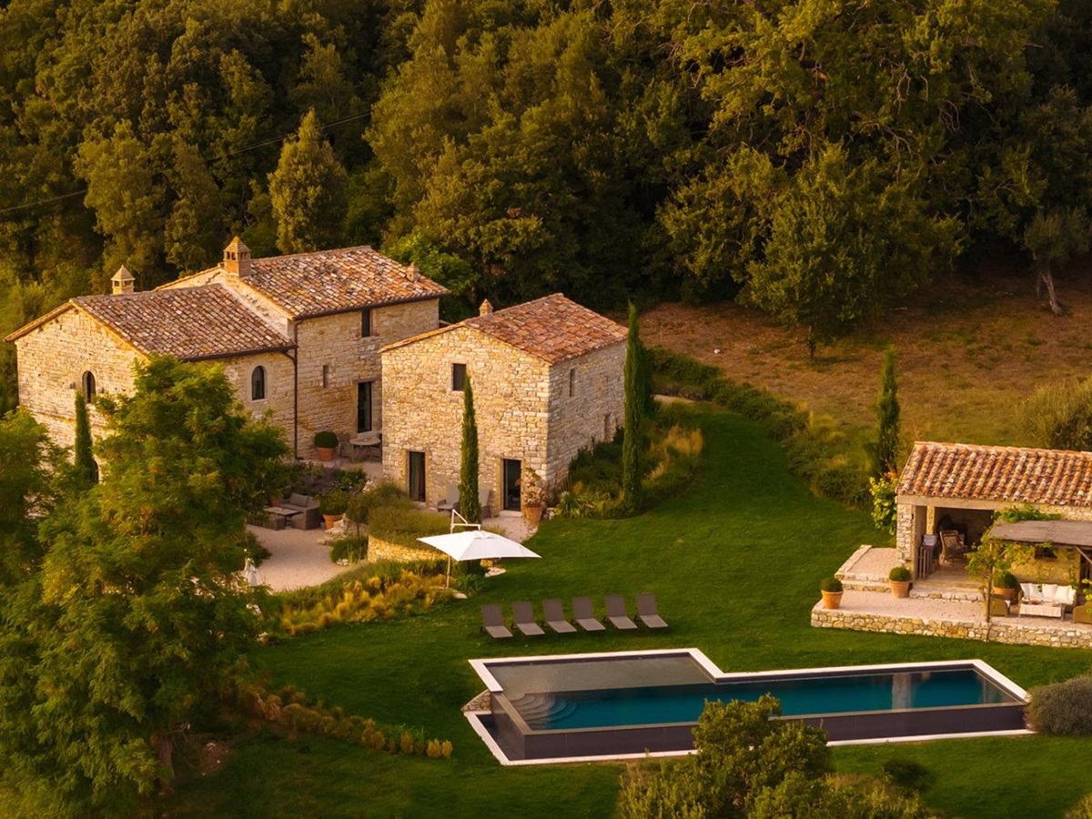 Drone view of the front of Villa Piuma in Umbria with view of the outdoor pool surrounded by trees