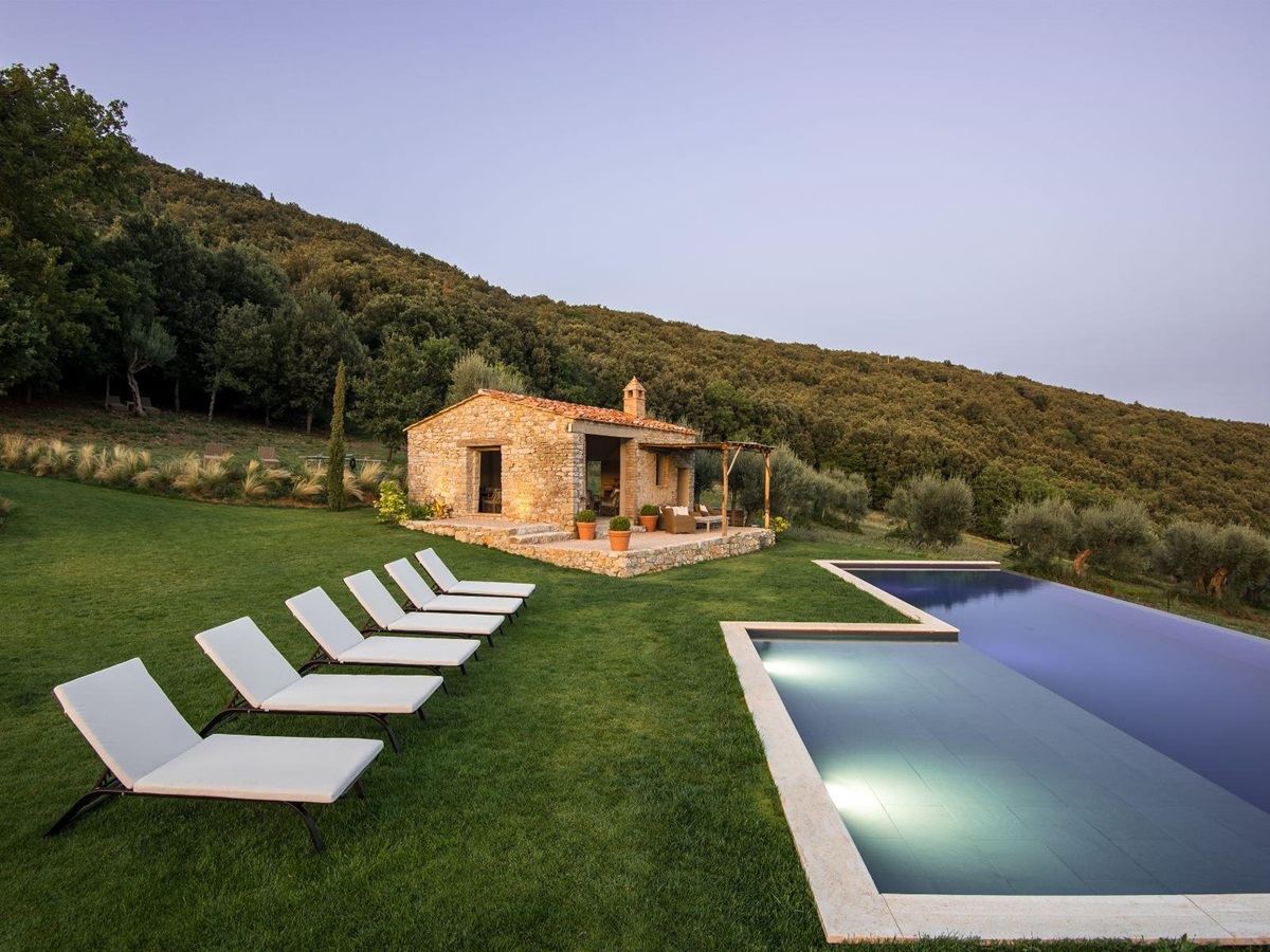 View of the outdoor pool and white sun loungers at Villa Piuma in Umbria