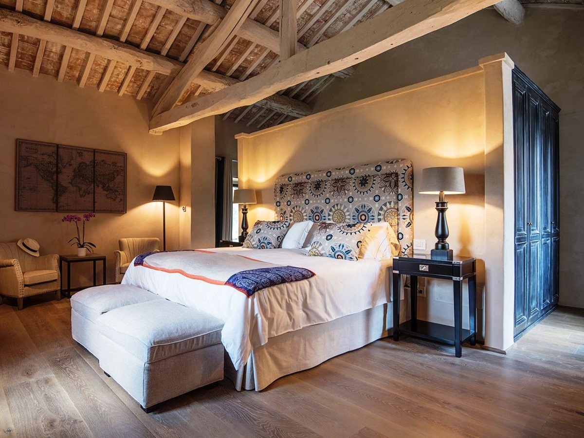 Double bedroom with closets with blue doors, two comfy chairs and tables at at Villa Piuma in Umbria, Italy