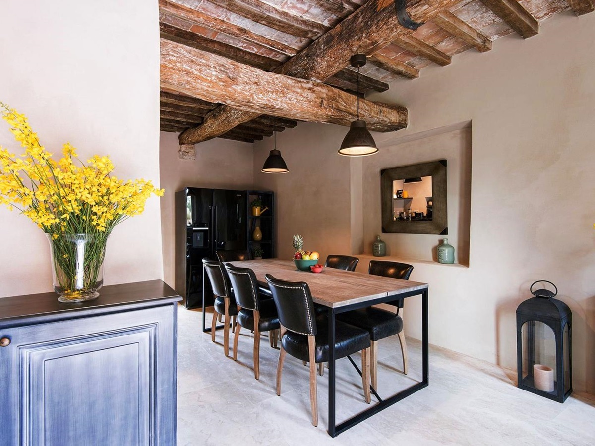 Dining table and 5 chairs in dining area with beamed ceiling at Villa Piuma in Umbria, Italy