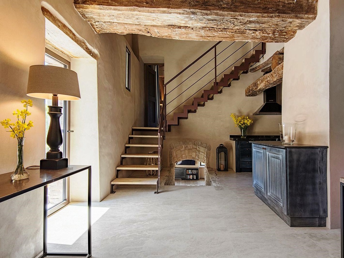 Hallway with stairs upstairs and steps downstairs to kitchen at Villa Piuma in Umbria, Italy