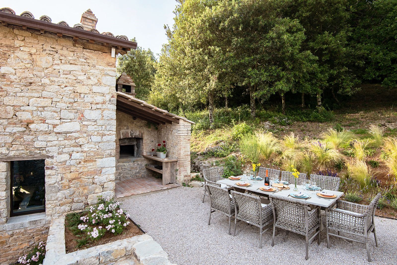 Kitchen garden with long table set for lunch and 8 chairs at Villa Piuma in Umbria, Italy