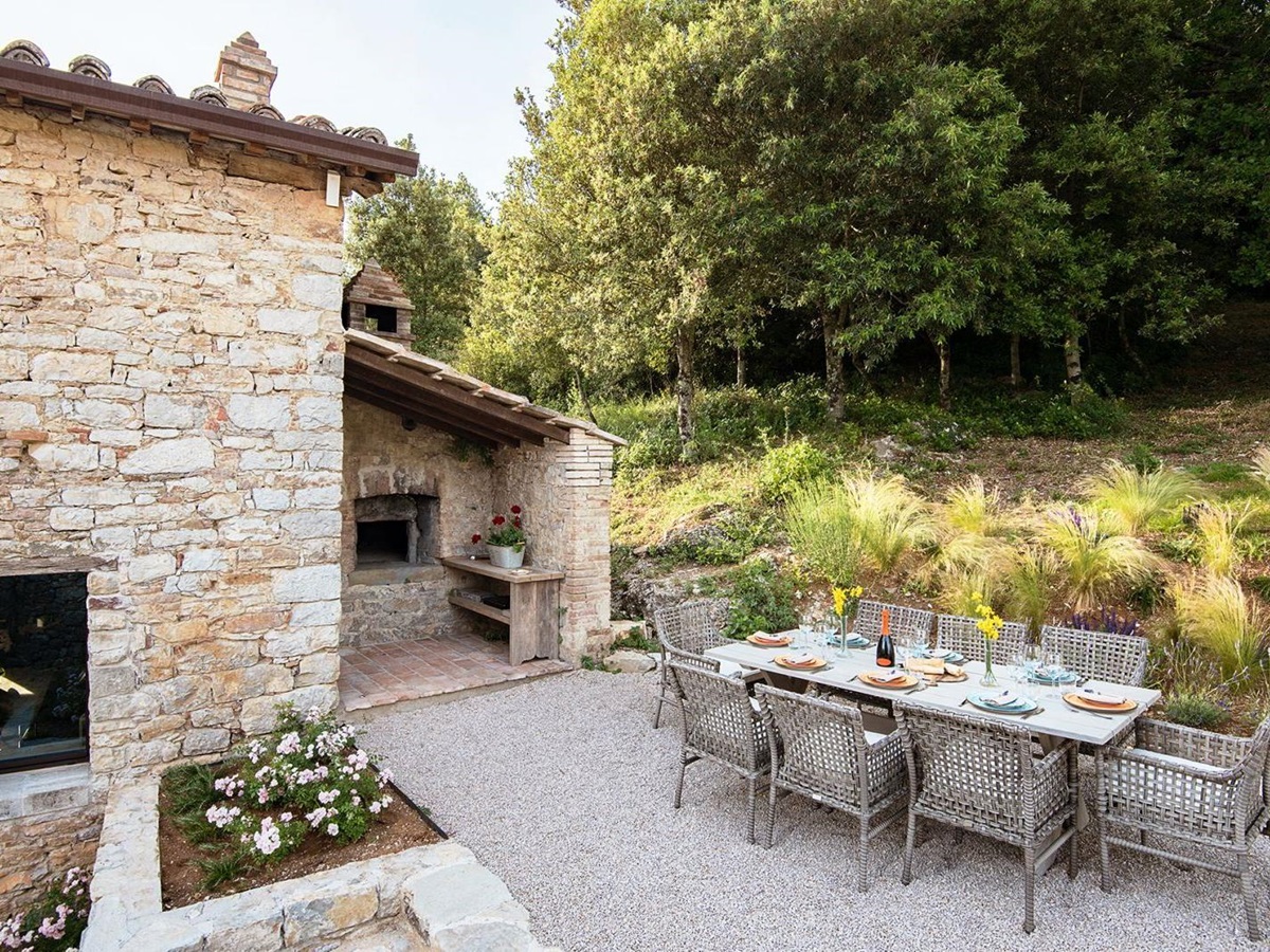 Kitchen garden with long table set for lunch and 8 chairs at Villa Piuma in Umbria, Italy