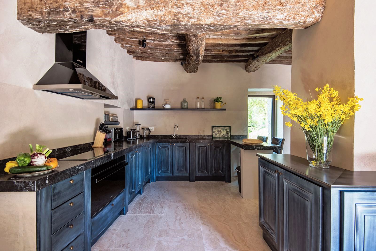 Kitchen with blue grey units and beamed ceiling at Villa Piuma in Umbria, Italy
