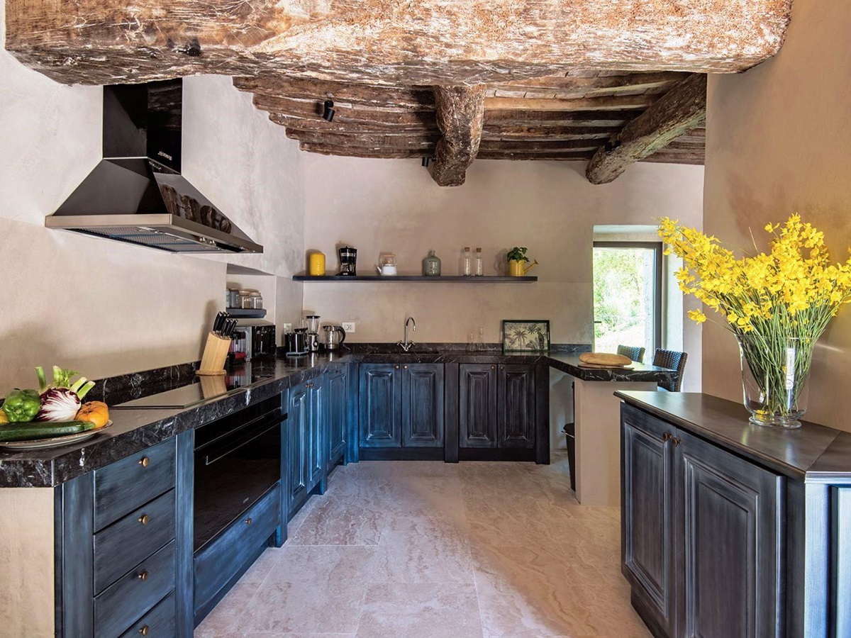Kitchen with blue grey units and beamed ceiling at Villa Piuma in Umbria, Italy