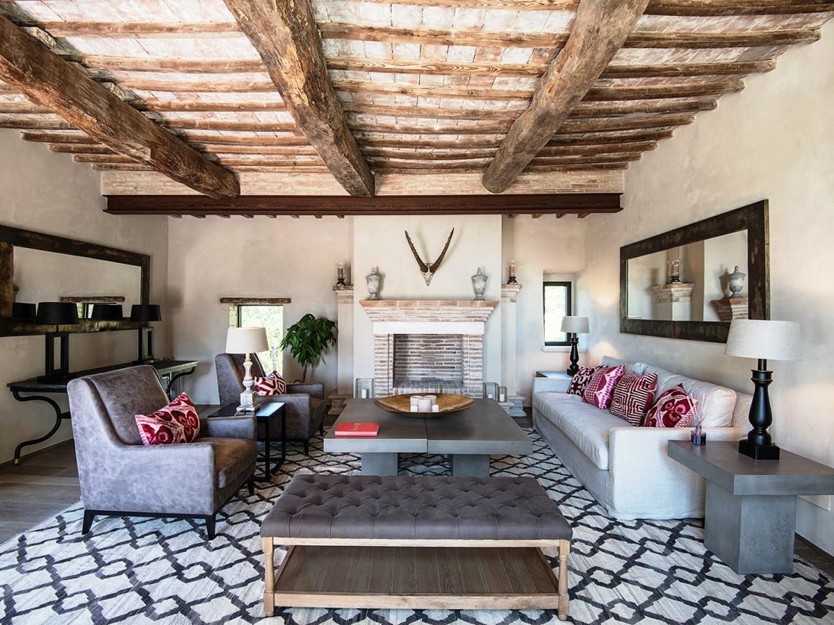 Sitting room with patterned floor, beamed ceiling, sofa, chairs and marble tables at Villa Piuma in Umbria, Italy