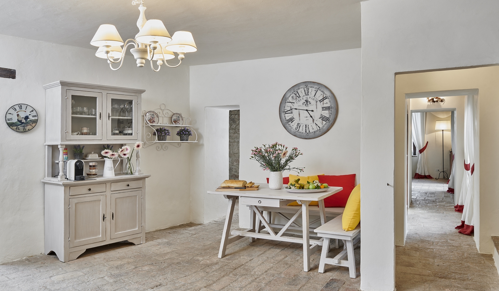 Kitchen with large clock and seating at Villa Pizzicato in Umbria