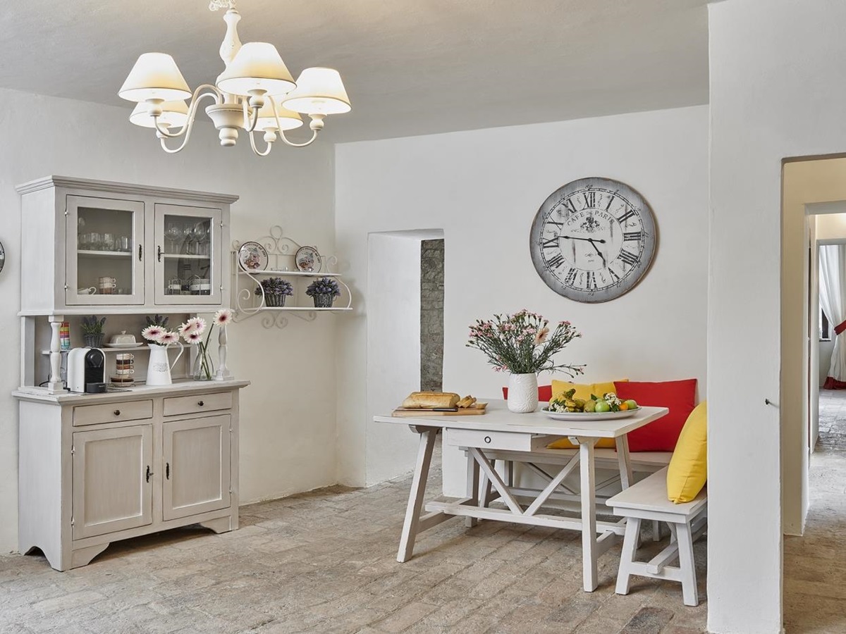 Kitchen with large clock and seating at Villa Pizzicato in Umbria