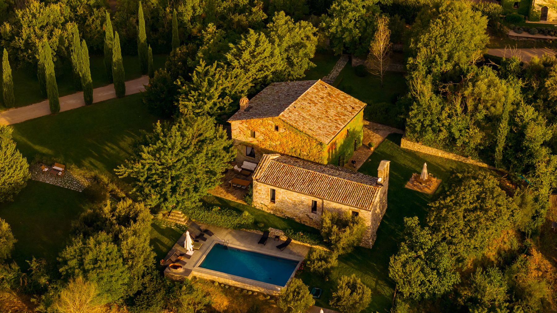 Drone view of Villa Pizzicato in Umbria with view of the property and the pool surrounded by trees