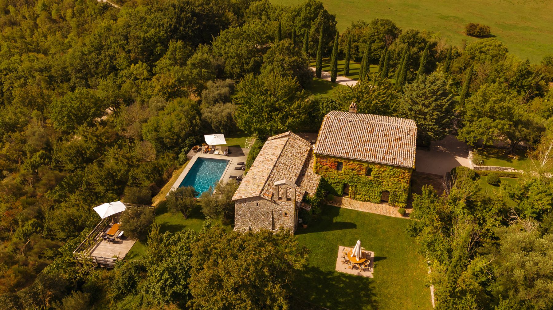 View of Villa Pizzicato in Umbria with view of the pool surrounded by trees