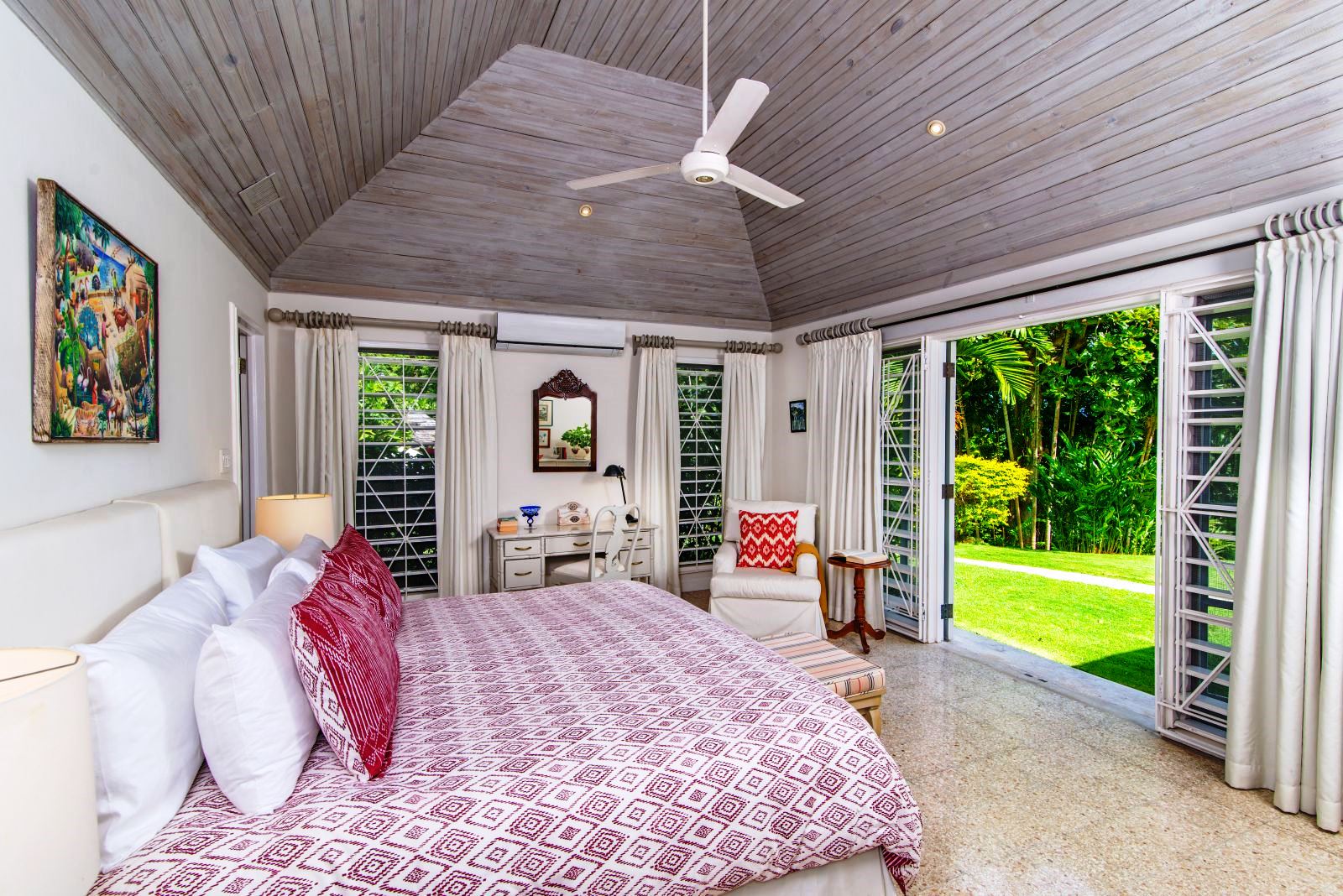 double bed with pink bedspread and doors onto garden at Almond Hill Villa, Montego Bay Jamaica