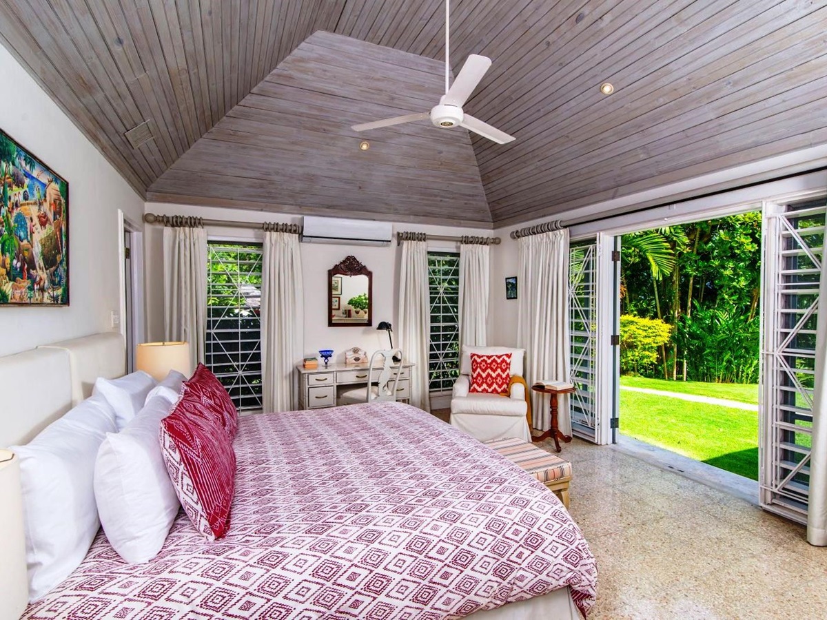 double bed with pink bedspread and doors onto garden at Almond Hill Villa, Montego Bay Jamaica