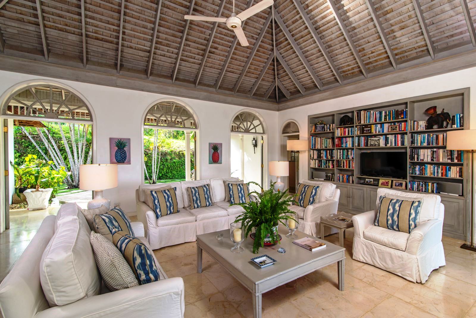 sitting area with white couches, coffee table and book shelves at Almond Hill Villa, Montego Bay Jamaica