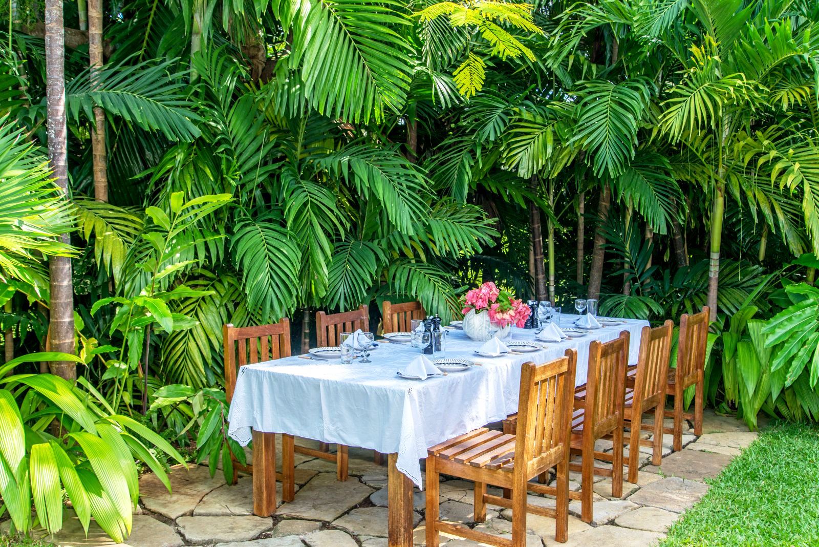 long table with white cloth and eight wooden charis outdoors at Almond Hill Villa, Montego Bay Jamaica