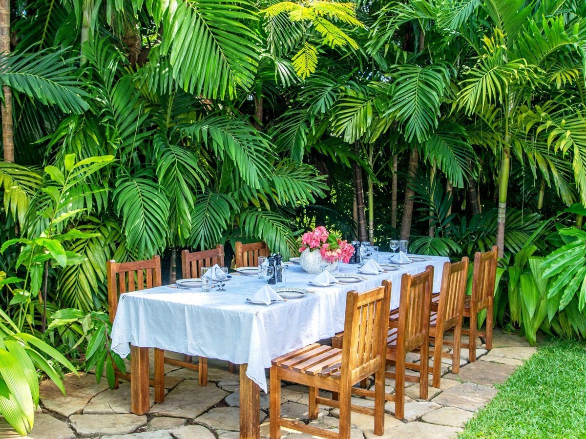 long table with white cloth and eight wooden charis outdoors at Almond Hill Villa, Montego Bay Jamaica