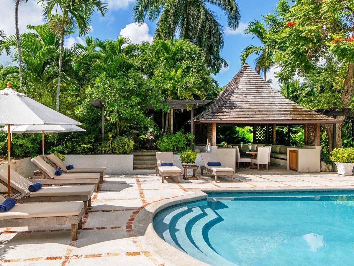 edge of swimming pool with sun loungers and umberellas at Almond Hill Villa, Montego Bay Jamaica