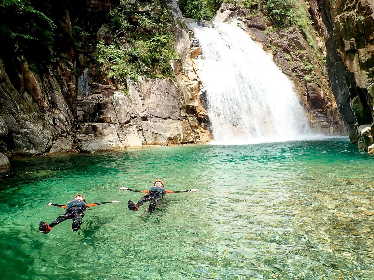 Guests floating around the waterfall at Zenagi