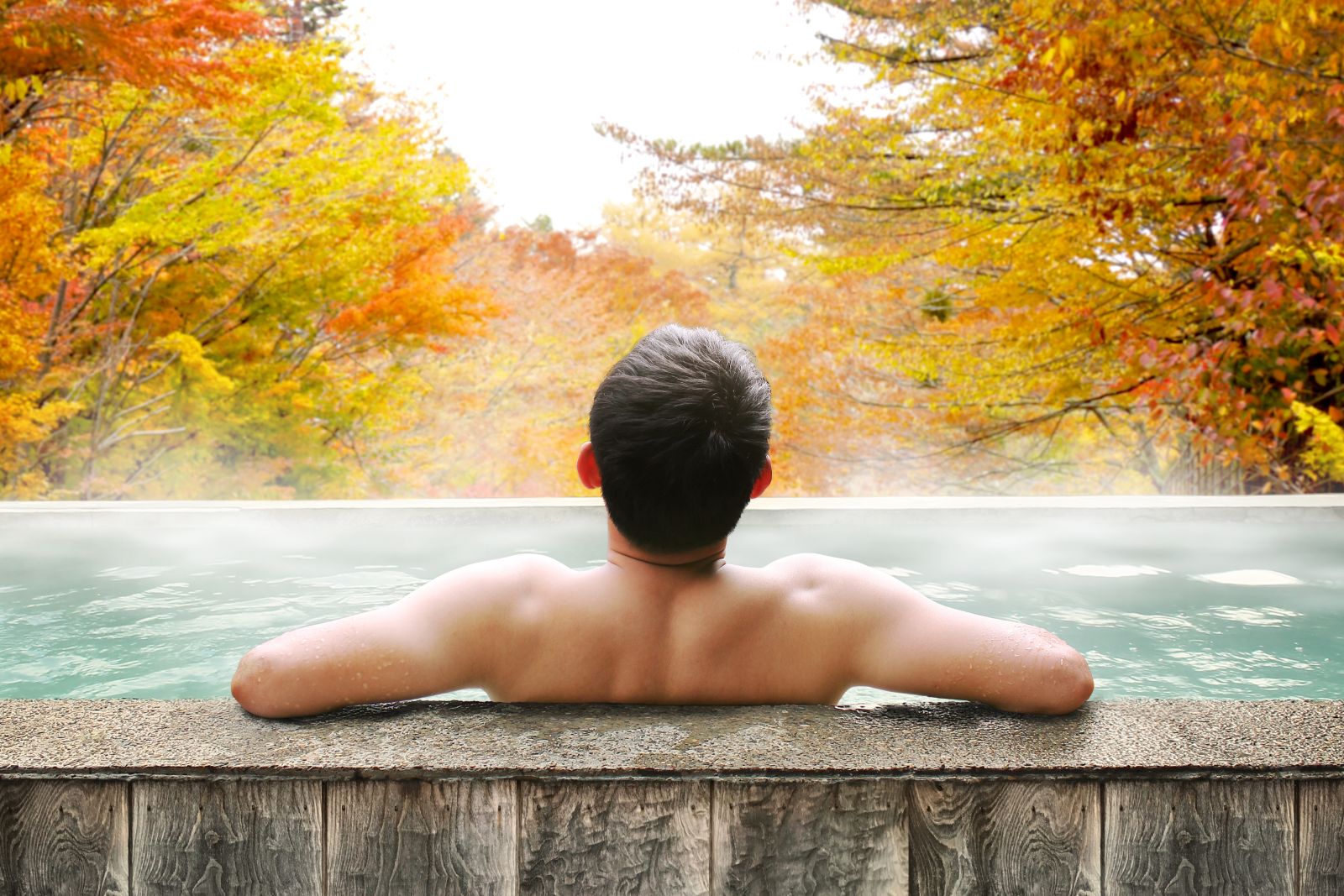 Man soaking in an outdoor onsen spa in Japan