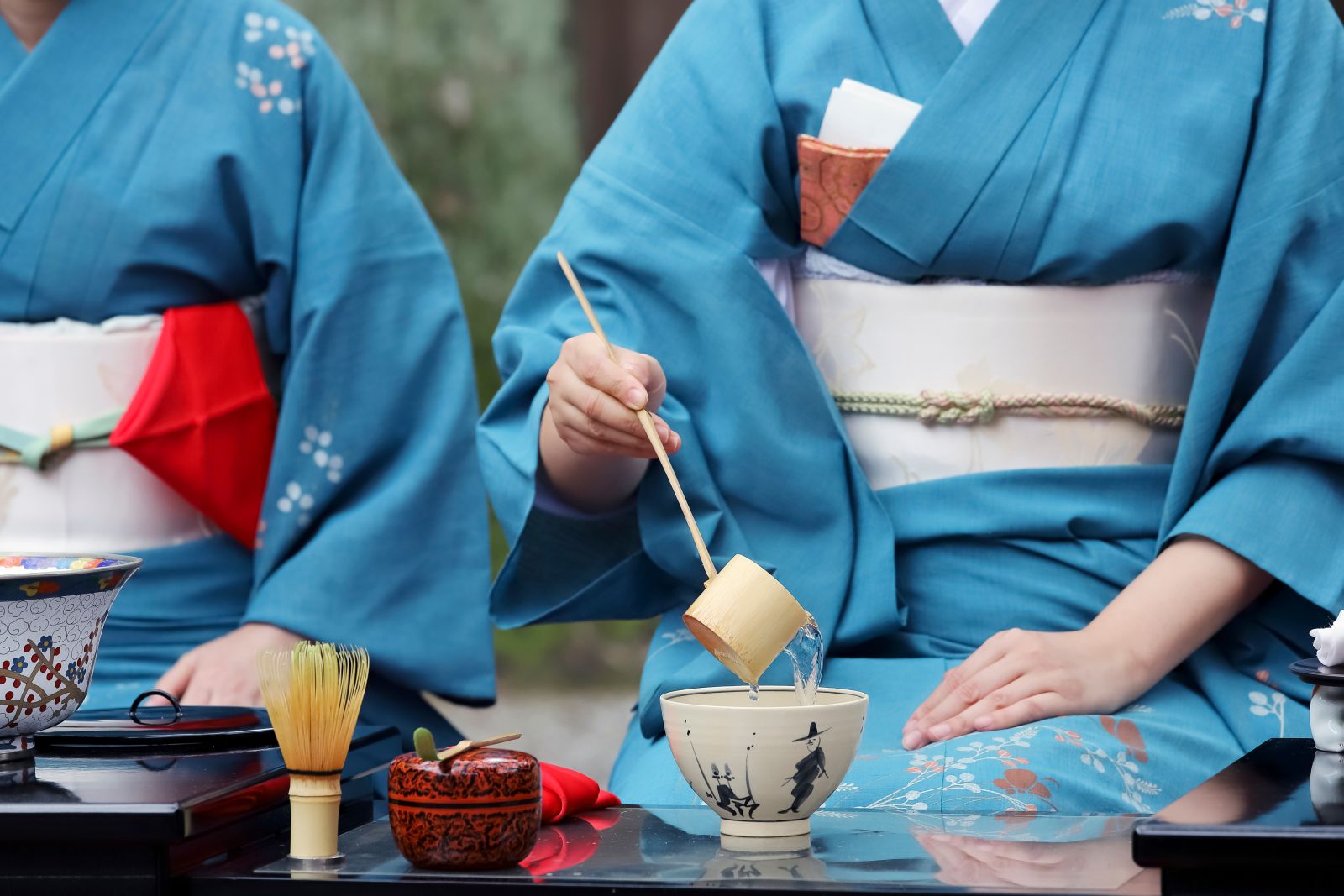 Ladies in kimonos performing a typical tea ceremony in Japan