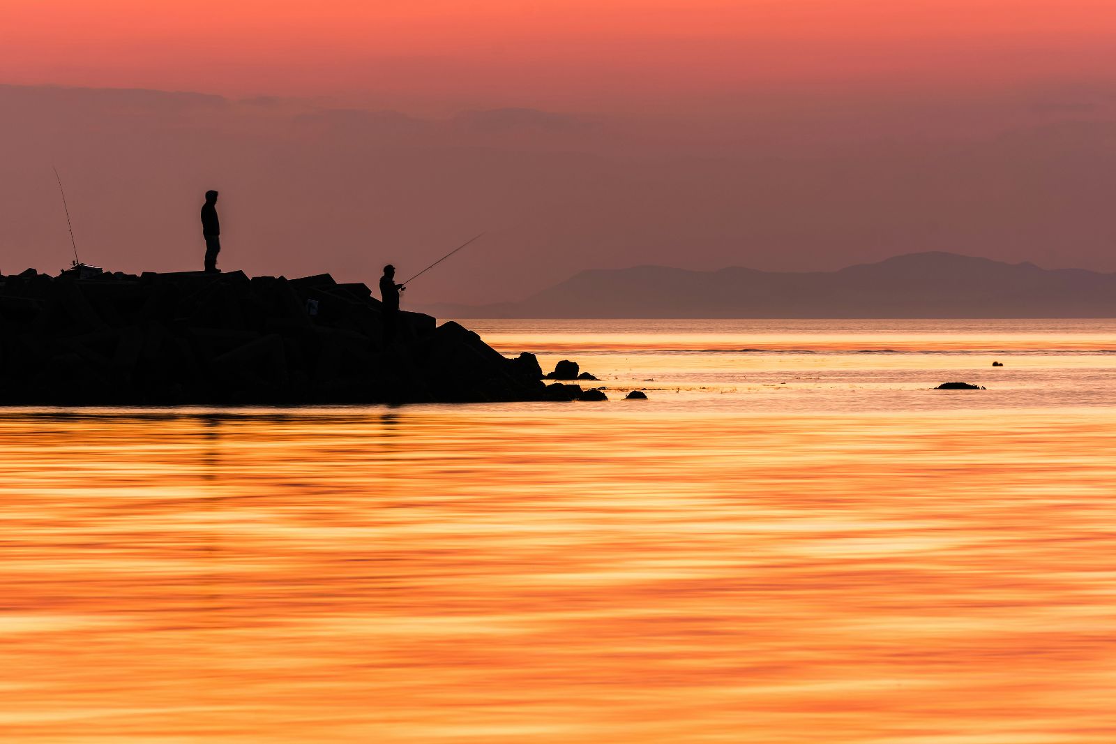 Silhouette of fishermen at dusk on the shores of Japan's Seto Inland Sea