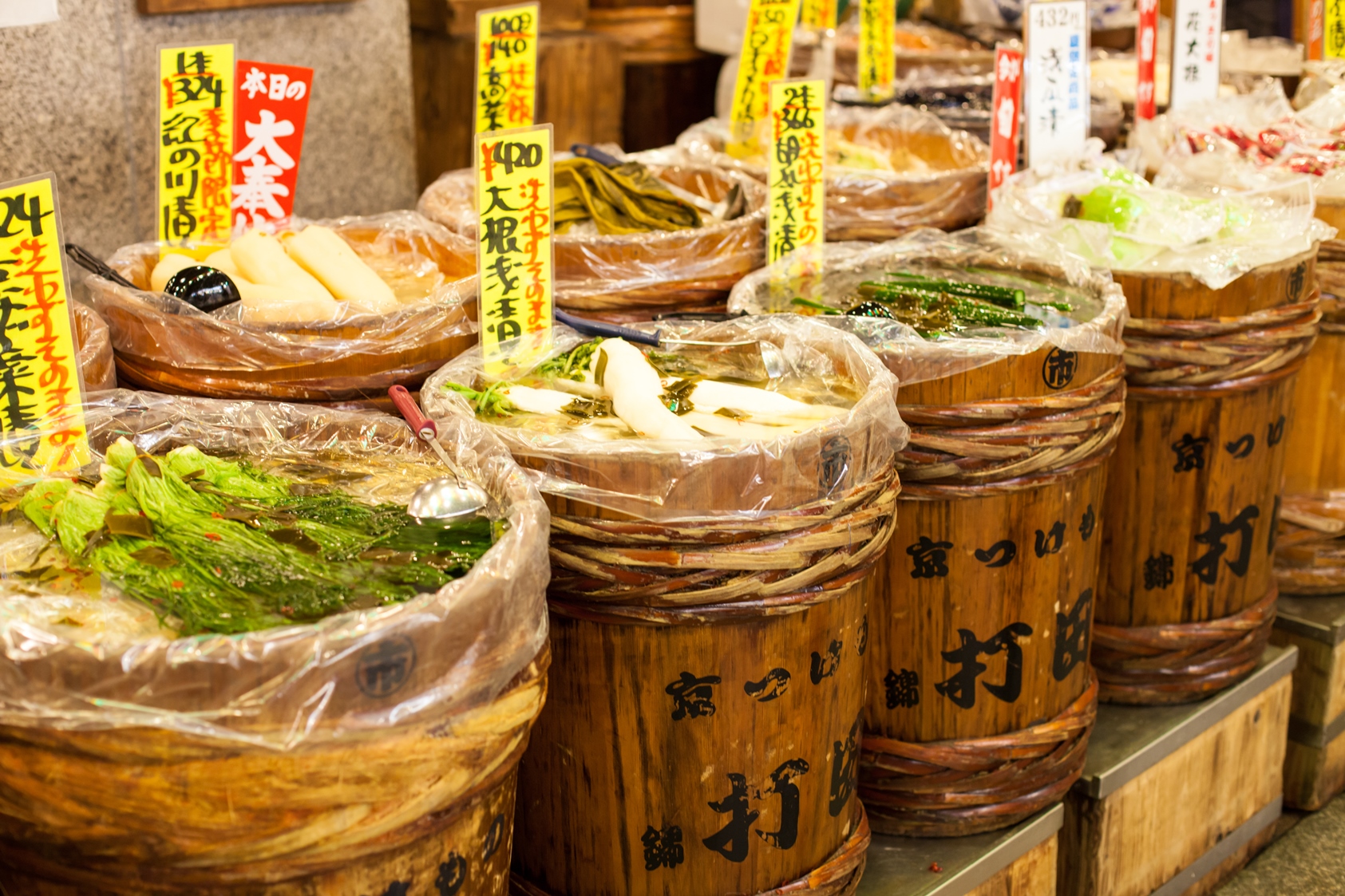 Wooden barrels containing vegetables and food at a traditional Japanese market
