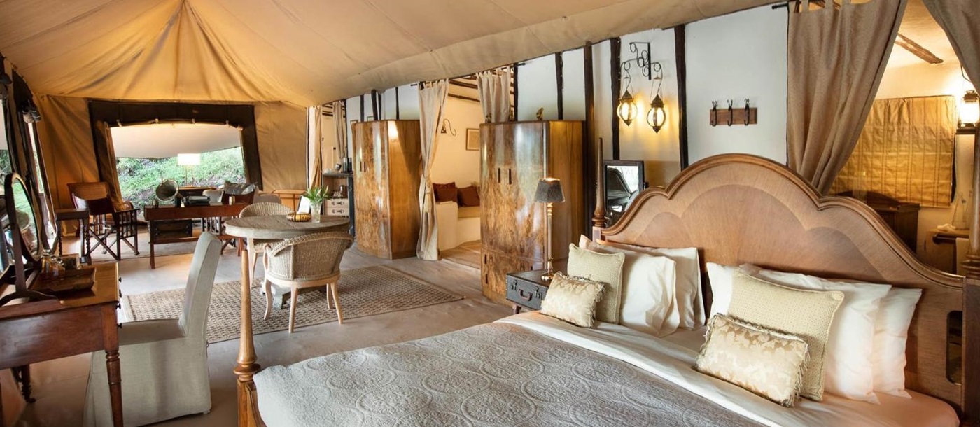 Honeymoon tent bedroom with lounge and dining area at luxury lodge Cottar's 1920s Camp in the Maasai Mara, Kenya