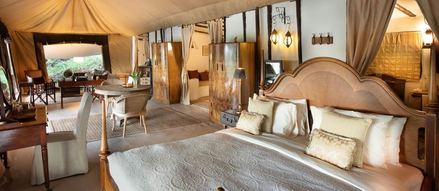 Honeymoon tent bedroom with lounge and dining area at luxury lodge Cottar's 1920s Camp in the Maasai Mara, Kenya