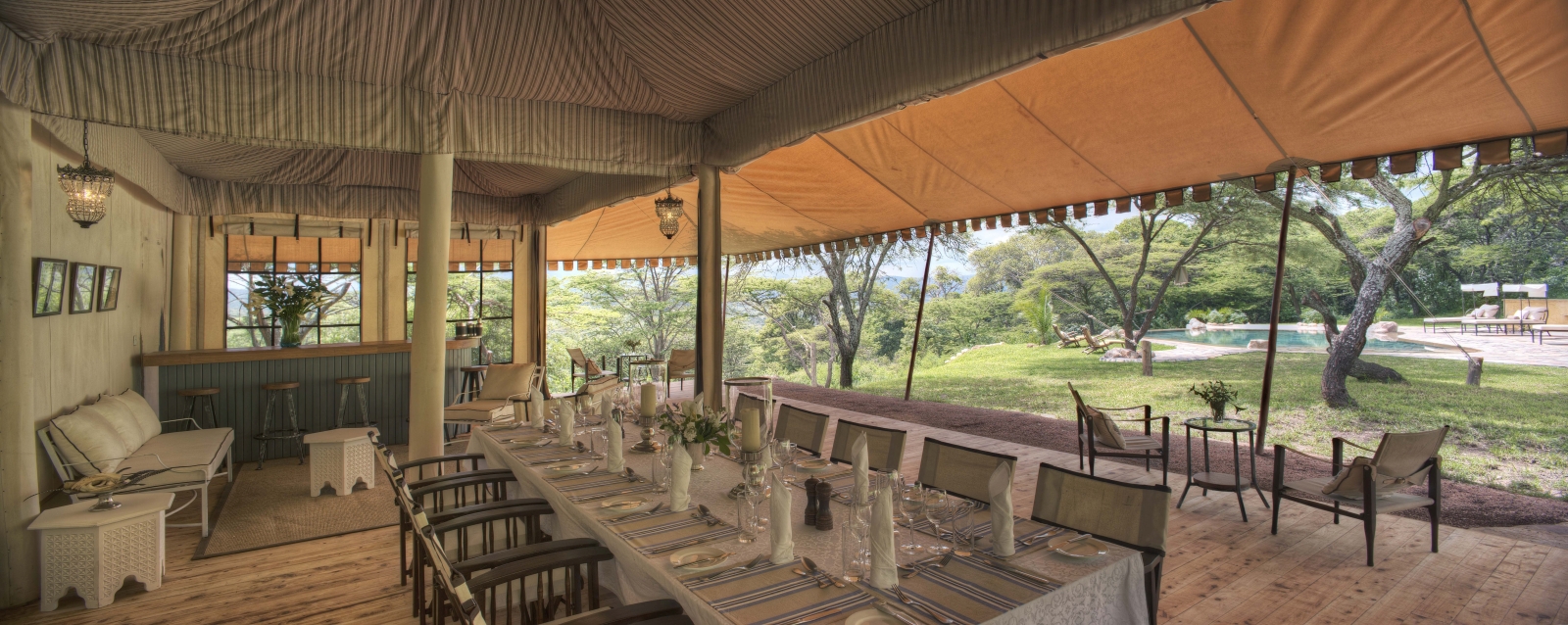 Pool-side dining and bar at luxury safari lodge Cottar's 1920's Safari Camp in the Maasai Mara, Kenya