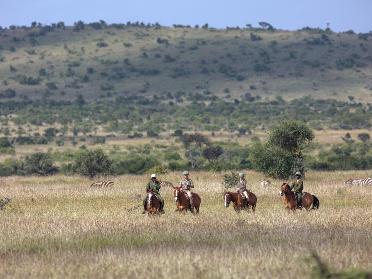 Guests on a horse ride in the African bush at luxury safari lodge Lodo Springs in the Laikipia region of Kenya