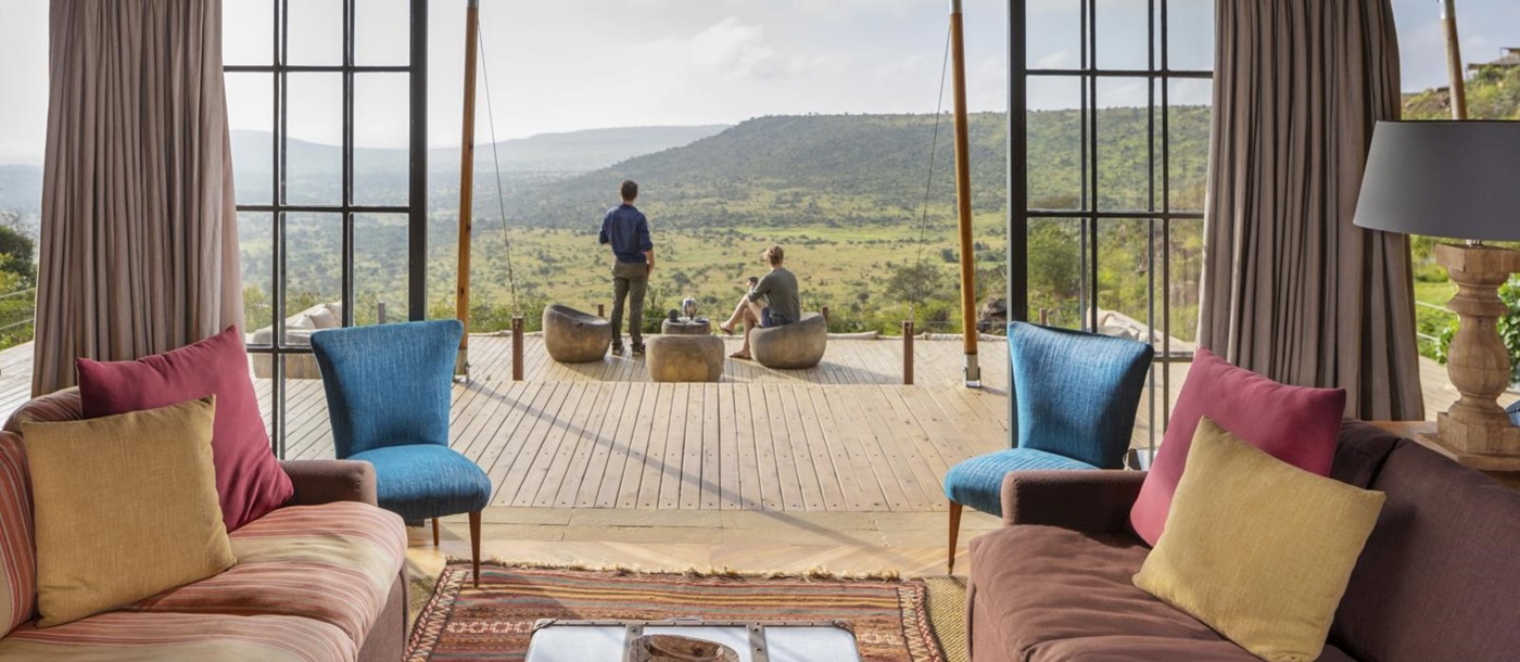 two guests enjoying the view from the main deck outside the lounge at luxury safari lodge Lodo Springs in the Laikipia region of Kenya